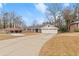 Brick ranch house with a two-car garage and landscaped yard at 1283 Woodleigh Sw Rd, Marietta, GA 30008