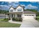 Two-story house with a front porch, two-car garage, and landscaped yard at 3109 Bentley Farms Dr, Loganville, GA 30052