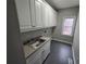 Laundry room with built-in cabinets and utility sink at 7910 Tintern Trce, Duluth, GA 30097