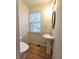 Small bathroom with pedestal sink and wood-look floors at 2104 Meadow Peak Rd, Duluth, GA 30097