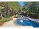 Aerial view of kidney-shaped pool with surrounding patio and trees at 3950 Stanford Dr, Cumming, GA 30041