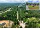 Aerial view showing a house nestled in a wooded lot with a long driveway at 530 Penny Ln, Loganville, GA 30052