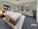 Virtually staged main bedroom with three windows and wood flooring at 2491 Emma Way, Lawrenceville, GA 30044