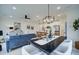 Open concept dining area with a large black table and white chairs, adjacent to the living room and kitchen at 401 Carrera Ln, Acworth, GA 30102