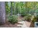 Landscaped backyard with a dog house and brick pathway at 117 N Cove Dr, Peachtree City, GA 30269