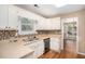 Galley style kitchen with white cabinets and tile backsplash at 5623 Yeager Ridge Dr, Douglasville, GA 30135