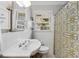 Clean bathroom with white tile, pedestal sink, and patterned shower curtain at 3027 Saint Annes Nw Ln, Atlanta, GA 30327