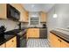 Updated kitchen with light wood cabinets, granite counters, and patterned floor tile at 3027 Saint Annes Nw Ln, Atlanta, GA 30327