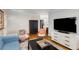 Living room with hardwood floors, comfy seating, and a large TV at 3027 Saint Annes Nw Ln, Atlanta, GA 30327