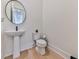 Clean powder room with pedestal sink, toilet and hardwood floor at 2144 Suncrest Pt, Marietta, GA 30064