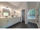 Spa-like bathroom with double vanity, dark tile floors, and a window at 700 Wilson Mill Sw Rd, Atlanta, GA 30331