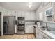 Galley kitchen with stainless steel appliances and white cabinets at 850 Kenwood Ln, Jonesboro, GA 30238