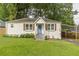 Charming white brick ranch home with a blue door, landscaped lawn, and carport at 723 Campbell Cir, Hapeville, GA 30354
