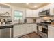 Modern kitchen with white cabinets, granite countertops, and stainless steel appliances at 723 Campbell Cir, Hapeville, GA 30354