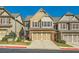 Two-story townhome with brick and siding exterior, three-car garage, and landscaped yard at 1510 Dolcetto Nw Trce, Kennesaw, GA 30152