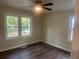 Spacious bedroom with large windows, ceiling fan, and dark laminate flooring at 1303 Rocksprings St, Forest Park, GA 30297