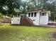 Charming white brick ranch with wood accent steps and landscaped lawn at 1303 Rocksprings St, Forest Park, GA 30297