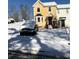 Snow-covered yard with a yellow house and a car parked in front at 800 Crestside Ct # 800, Austell, GA 30168