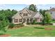 Two-story house with stone and siding, landscaped lawn, and a three-car garage at 125 Registry Ln, Canton, GA 30115