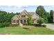 Two-story house with stone and siding, landscaped lawn, and a three-car garage at 125 Registry Ln, Canton, GA 30115