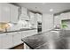 Modern kitchen with white cabinets, black countertops, and stainless steel appliances at 125 Registry Ln, Canton, GA 30115