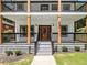 Inviting front porch with wooden columns and black railings at 490 Third Ave, Scottdale, GA 30079