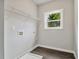 Laundry room with wire shelving, a window, and dark grey vinyl flooring at 490 Third Ave, Scottdale, GA 30079