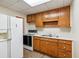 Simple kitchen with wood cabinets, white appliances, and laminate floor at 1930 Ridge Rd, Cumming, GA 30041