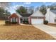 Brick ranch house with attached garage and landscaped yard at 2457 Swan Lake Dr, Grayson, GA 30017