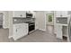 Modern kitchen with white cabinets, stainless steel appliances, and grey backsplash at 1886 S Hidden Hills Pkwy, Stone Mountain, GA 30088