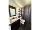 Updated bathroom with dark vanity and gray floor at 3571 Quail Hollow Trl, Snellville, GA 30039