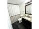 Updated bathroom with dark vanity and gray floor at 3571 Quail Hollow Trl, Snellville, GA 30039