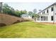 Spacious backyard with a retaining wall and grassy area at 2201 E Maddox Rd, Buford, GA 30519