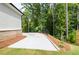 Large side yard with concrete patio and wooded backdrop at 2201 E Maddox Rd, Buford, GA 30519