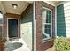 Front entry with brick and green siding and a black door at 7814 Bluefin Trl, Union City, GA 30291