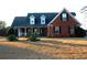 Brick home with dormer windows, porch, and landscaped yard at 321 Whitney Ln, Mcdonough, GA 30253