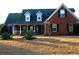 Brick home with dormer windows, porch, and landscaped yard at 321 Whitney Ln, Mcdonough, GA 30253