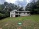 House with a large backyard, partially visible carport, and a green water meter cover at 3246 Wallace Lake Rd, Douglasville, GA 30135