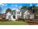 Two-story white brick home with a landscaped lawn and mature trees at 2753 Pinebloom Way, Duluth, GA 30097