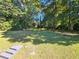 Large backyard with grassy lawn and mature trees at 6692 Cambridge Dr, Rex, GA 30273