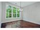 Bright dining room with hardwood floors and a large window overlooking trees at 101 Forsyth Park Ln, Woodstock, GA 30188