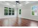 Main bedroom featuring hardwood floors, tray ceiling and multiple windows at 101 Forsyth Park Ln, Woodstock, GA 30188