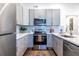 L-shaped kitchen with gray cabinets, stainless steel appliances, and a decorative rug at 116 Turman Se Ave, Atlanta, GA 30315