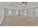 Spacious main bedroom with neutral carpet, ceiling fan and multiple windows at 381 Paper Woods Dr, Lawrenceville, GA 30046