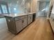 Large kitchen island with quartz countertop and gray cabinets at 7125 Winderlea Ln, Cumming, GA 30040