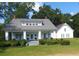 White farmhouse with wrap-around porch, landscaping, and detached garage at 788 S Hwy 11 S, Social Circle, GA 30025