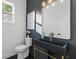 Modern powder room with a black sink, gold accents, and dark-colored walls at 156 Martha Ne Ave, Atlanta, GA 30317