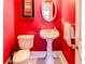 Small bathroom with pedestal sink and red walls at 25 Inverleigh Row, Covington, GA 30014