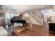 Open living room with hardwood floors, grand piano, staircase, and barn doors at 101 Morgan Ln, Canton, GA 30115