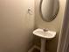 Small powder room with pedestal sink and oval mirror at 837 Crestwell Sw Cir, Atlanta, GA 30331